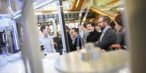 People stand in an atrium next to a robotic machine.